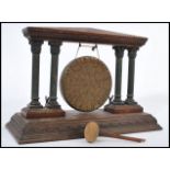 A 19th century oak and bronze table gong, the central hanging gong flanked by metal columns either