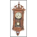 A Vienna-styled wall clock, oak case with opening glazed door flanked by turned decoration,