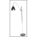 A contemporary floor standing standard / reading /spot lamp. The lamp on a chrome circular base with