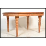 A vintage 20th century large teak wood dining table by Rainforest furniture raised on turned legs