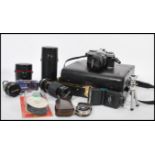 A collection of vintage cameras to include SLR camera body, SLR lenses to include zoom, protective