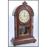 An early 20th century mahogany cased mantel clock raised on a plinth base with bun feet. Glazed door