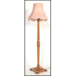 A vintage early 20th century Art Deco wooden standard lamp raised on square base with shaped