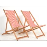 A pair of retro mid 20th century wooden and canvas upholstered deck chairs. The slatted seats with