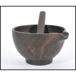 A 19th century cast iron pestle and mortar of simple form with single shaped lip. Bowl 10cm high.