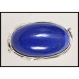 A stamped 925 silver ring having a large oval lapis lazuli stone with pierced floral decoration to