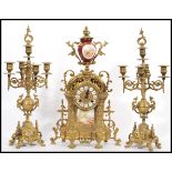 A vintage 20th century German gilt brass mantel clock and garniture set. The clock with red