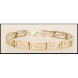 A 9ct gold spacer bracelet having pierced greek key detailing. Weight 12.2g.