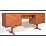 A 1970's teak wood dressing table - pedestal writing desk. Of low and wide form being raised on