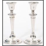 A pair of 20th century silver hallmarked candlesticks raised on stepped circular bases with tapering