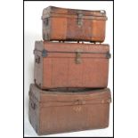 A set of three graduating scrumble painted steamer / tack trunks, all with fitted hinged lids and