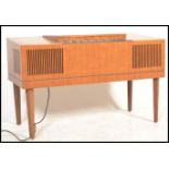 A retro HMV mid century teak wood stereogram having tapering legs with grill front, hinged top