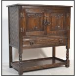 An Old Charm / Jaycee style oak hall cupboard having carved linen fold decoration being raised on