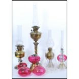 A selection of 19th Century Victorian oil lamps and oil lamp parts to include a brass lamp raised on