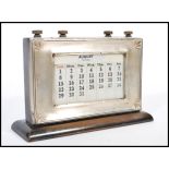 An early 20th century silver hallmarked perpetual desk calendar by W J Myatt & Co mounted on