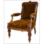 A Victorian 19th century mahogany library armchair being raised on reeded, turned legs with white