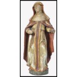 A 19th century carved wooden polychrome figurine of a nun. The religious ecclesiastical adorned in