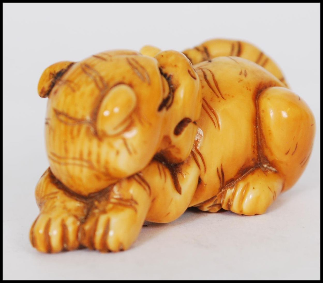 A rare Meiji period ivory Netsuke of a crouching tiger, its head turned back with long striped - Image 3 of 10