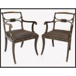 A pair of early 19th century Regency ebonised and gilt parcel armchairs. Raised on reeded sabre