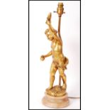 A 20th century classical revival gilt plaster putti / cherub lamp being raised over a veined