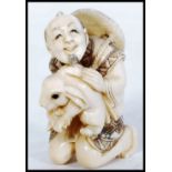 An unusual Japanese Meiji period carved ivory netsuke depicting a merchant man with large rabbit