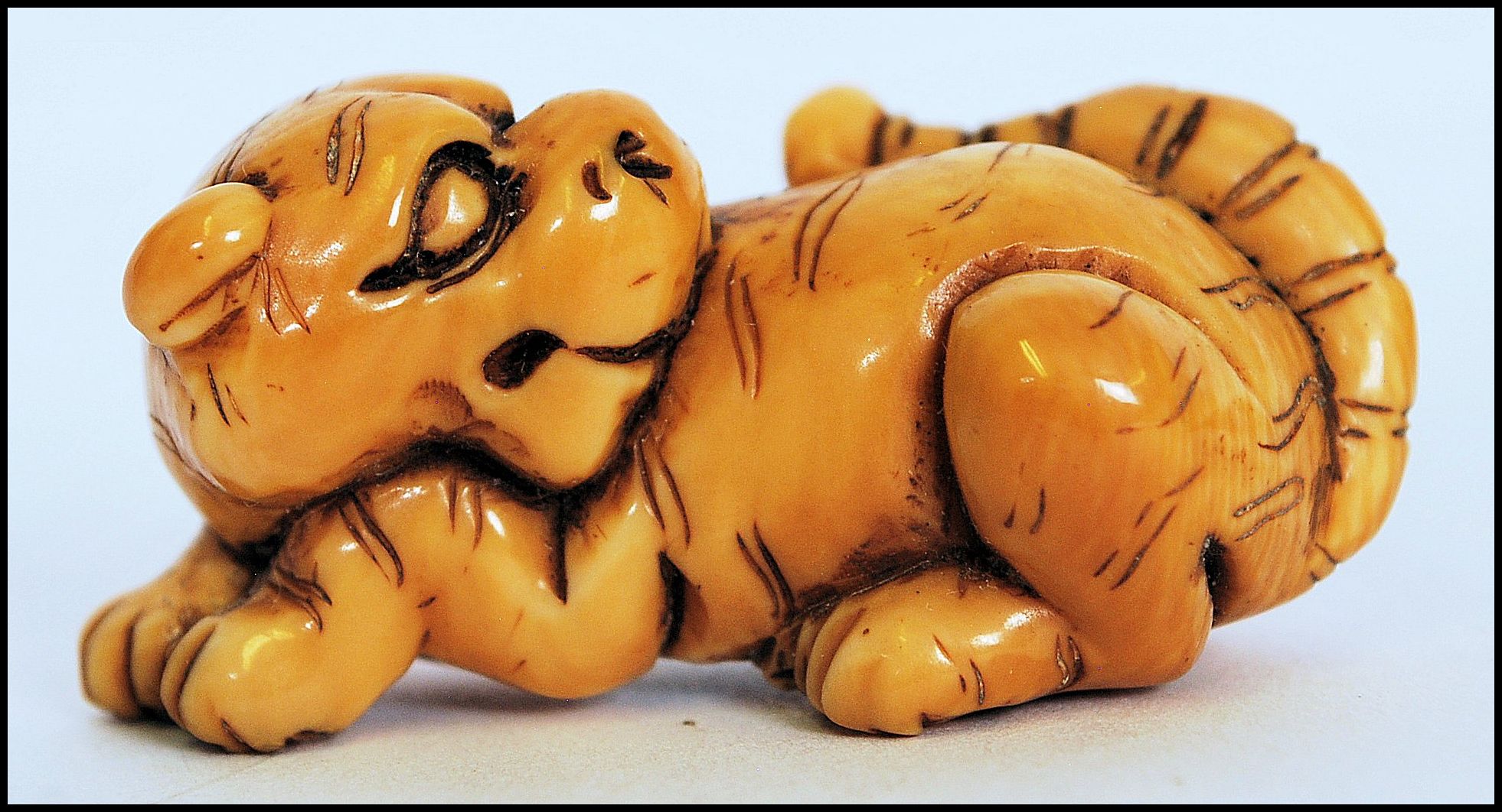 A rare Meiji period ivory Netsuke of a crouching tiger, its head turned back with long striped - Image 6 of 10