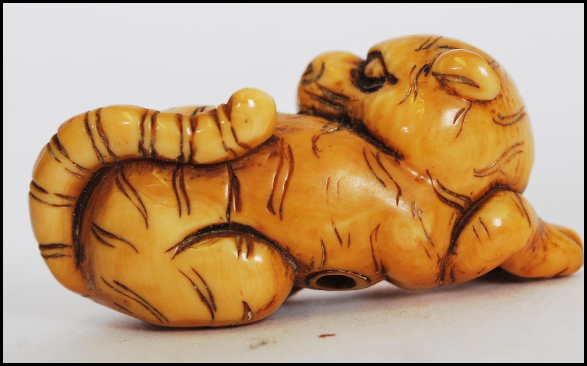 A rare Meiji period ivory Netsuke of a crouching tiger, its head turned back with long striped - Image 7 of 10