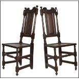 A pair of 17th Century oak dining chairs. Each chair with carved top rails, turned vertical splats