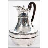 An early 19th century George III silver hallmarked hot water jug by Paul Storr raised on a small