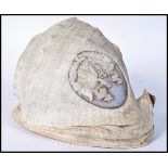 A large 19th century hand carved conch shell of typical form being detailed to top with a roundel