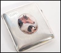 A silver hallmarked vesta cigarette case with an enamelled image of a horse and dog to the front.