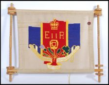 A vintage 20th century Royal QEII tapestry banner on turned wooden frame. 62cm high 74cm wide.