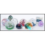 A collection of nine 20th century glass paperweights, the paperweights predominately by Caithness,