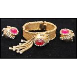 A vintage 1950s Hobé bracelet and earring set consisting of a mesh gold-tone bracelet set with a