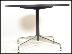 After Charles & Ray Eames - A contemporary round dining table. The table having a black finished oak