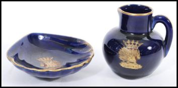 A porcelain miniature jug having a royal blue glaze with a gilt crest of the Order of the