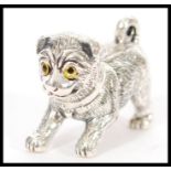 A stamped 925 silver figure of a pug dog having engraved detailing and yellow and black glass