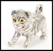 A stamped 925 silver figure of a pug dog having engraved detailing and yellow and black glass