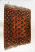 An early 20th century Persian rug with red ground having geometric borders, medallions to the