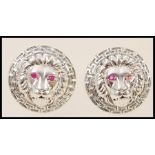 A pair of stamped sterling silver designer style cufflinks with embossed lion heads and greek key