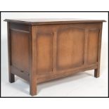 A 20th century oak Jacobean revival blanket box, panel sides with squared legs and hinged top above.