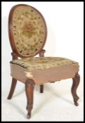 A 19th Century Victorian mahogany framed nursing chair having green and red needlework panels to the