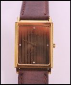 A vintage Raymond Weil 18k gold plated watch set to leather strap. Gilt dial with four white stone