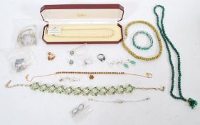 A group of silver and costume jewellery to include rings, green rhinestone floral necklace, boxed