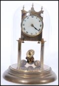 Mid 20th Century brass anniversary or torsion clock having a white face with arabic numerals to