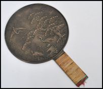 A 19th century Japanese bronze hand mirror having cane wrapped handle. The central circular mirror