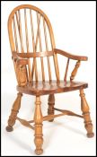 A 20th Century Victorian style country pine windsor arm elbow chair with railed spindle and hoop