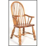 A 20th Century Victorian style country pine windsor arm elbow chair with railed spindle and hoop