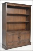 A 20th Century Ercol elm open bookcase, the bookcase having two adjustable shelves over to