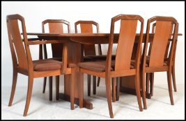 A 1970's retro teak wood dining room suite comprising a set of 6 dining chairs and an extending